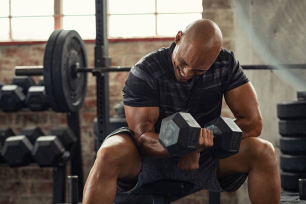 Man wincing while doing bicep curls