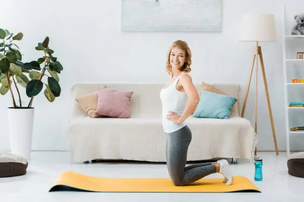 Woman smiling while performing kneeling squat