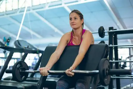 Woman performing preacher curls on bench