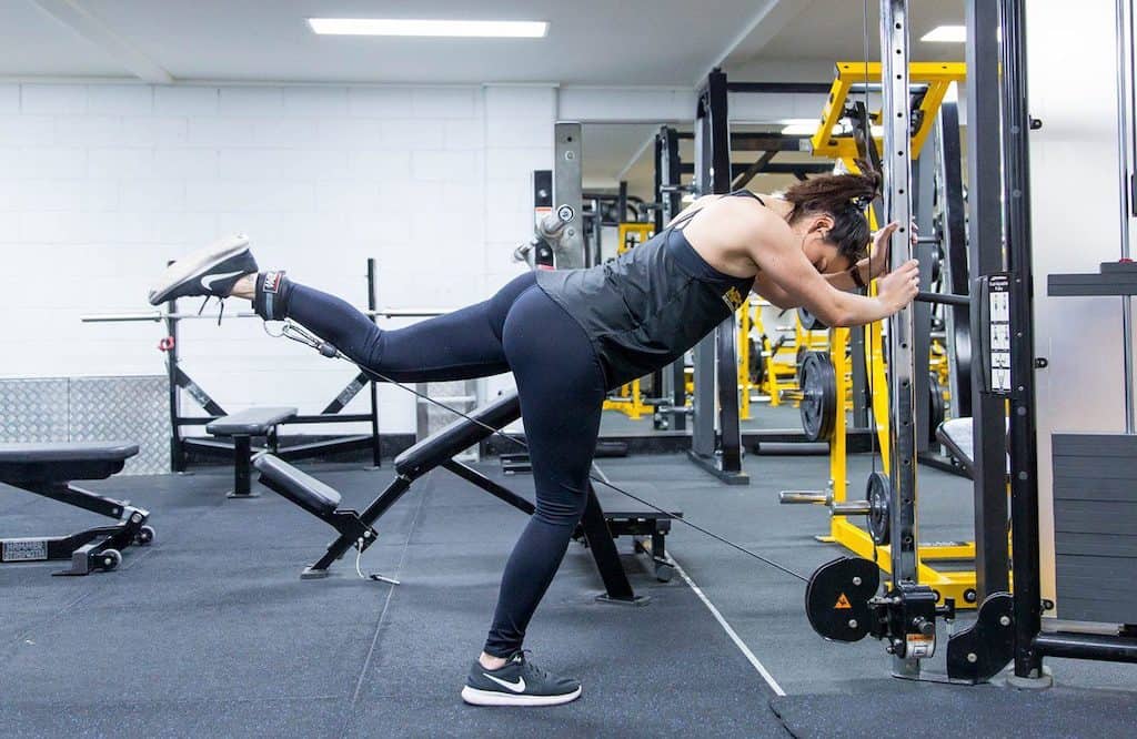 Woman doing cable glute kickbacks