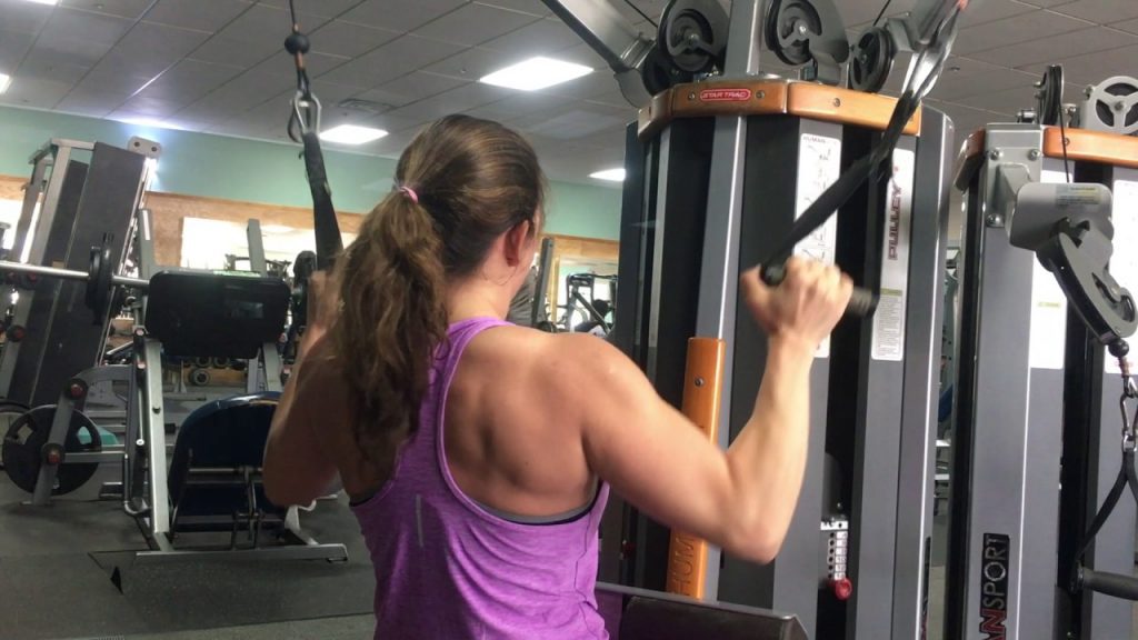 Lady using a dual cable lat pulldown machine