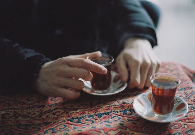 Hand holding glass of tea