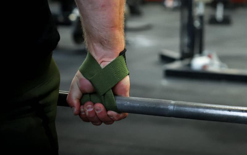 Guy deadlifting with lifting straps