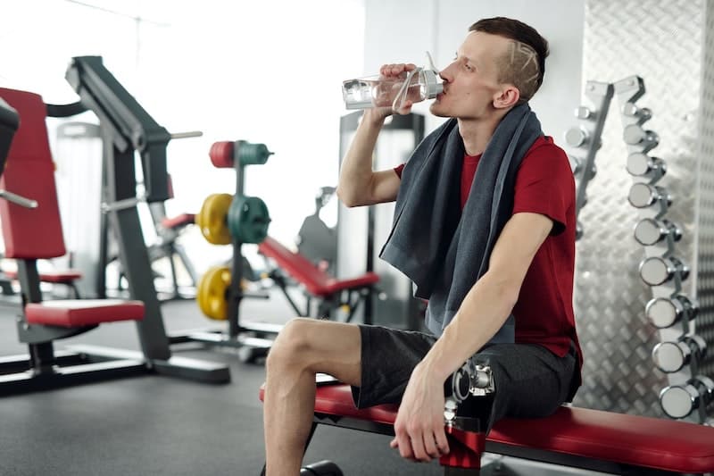 Guy drinking water at the gym