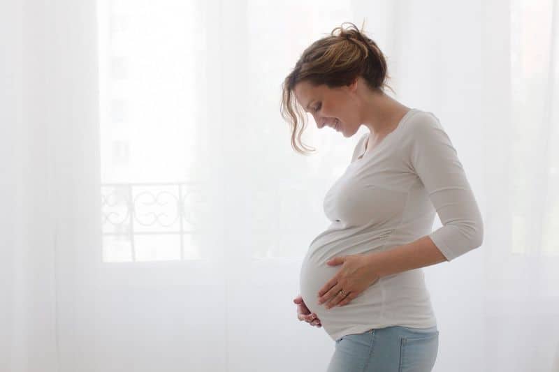 Pregnant woman holding belly