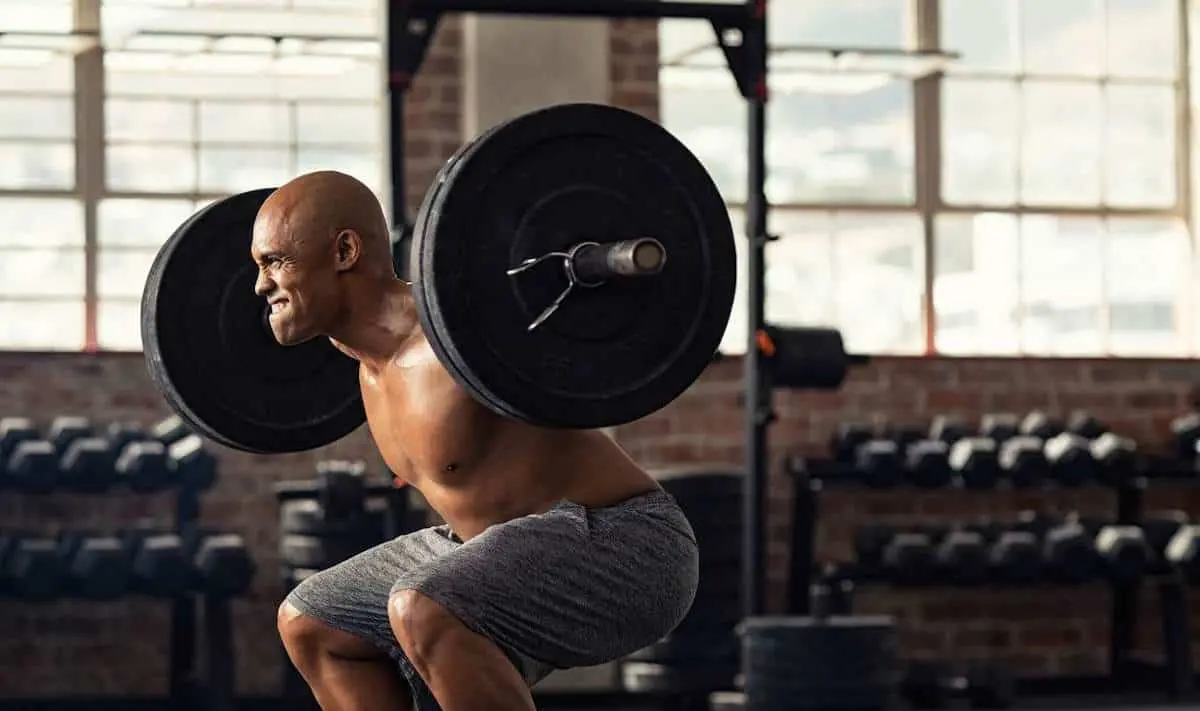 Man back squatting a barbell with weights