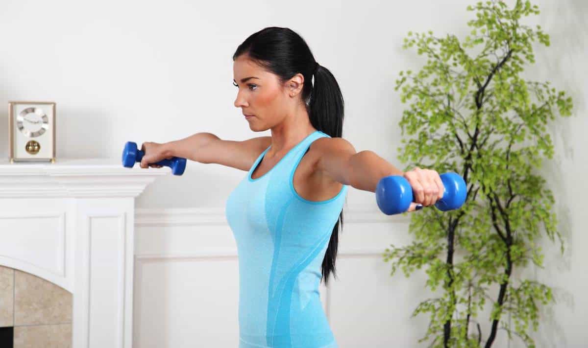 Woman doing lat raises at home